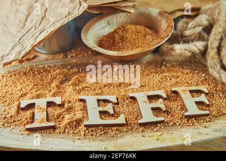 Teff, une alternative à l'ancien grain sans gluten avec le nom écrit en lettres de bois. Le téff est devenu un choix populaire pour une alimentation saine. Banque D'Images