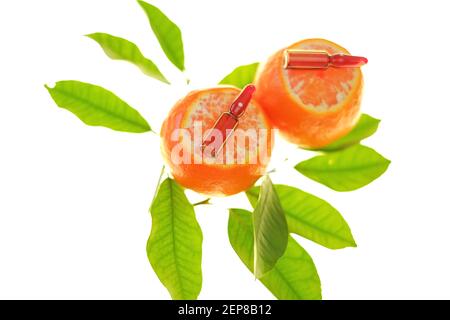 Vitamine C. sérum à la vitamine C. ampoules de verre gros plan sur les fruits de mandarines avec des feuilles de vert clair isolées sur fond blanc.prévention de Banque D'Images