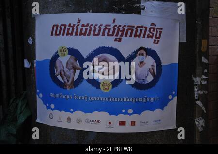 Au cours d'une épidémie de COVID - 19, l'USAID présente des affiches dans un script khmer avertissant les gens de se laver les mains, d'utiliser un désinfectant pour les mains et de porter des masques, dans un bidonville près du marché de Kandal, pendant la pandémie du coronavirus. Phnom Penh, Cambodge. © Kraig Lieb Banque D'Images