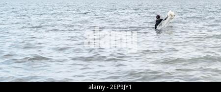 Pêcheur jetant le filet sur une plage pour en attraper poisson pendant la journée Banque D'Images