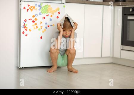 Un enfant à la maison pendant l'école à la maison ingeor apprend des leçons. Banque D'Images