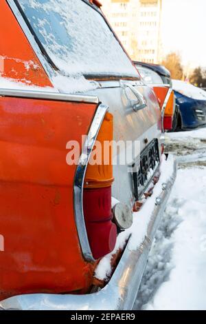 vieille voiture rétro brisée rouge rouillé vieux garé en hiver sur fond de neige le jour d'hiver glacial Banque D'Images