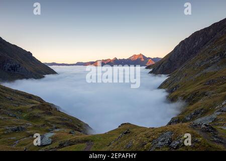 Au lever du soleil, vue sur la vallée de Timmeltal, en arrière-plan les sommets de Lasörling. Marée de nuages. Alpes autrichiennes. Europe. Banque D'Images