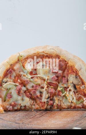 Photo verticale de la moitié de pizza mélangée sur fond de bois Banque D'Images