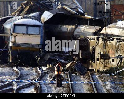 Photo du dossier datée du 01/03/01 d'un policier qui traverse la voie avec l'épave des trains derrière sur les lieux de Great Heck près de Selby, North Yorkshie, où deux conducteurs de train, deux autres membres du personnel du GNER et six passagers sont morts le 28 2001 février, Après que le service passagers de Newcastle à Londres a frappé un Land Rover qui avait rejoint l'autoroute M62 et s'est écrasé sur la piste. Date de publication : samedi 27 février 2021. Banque D'Images