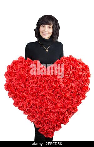 Jeune femme brune tenant un grand coeur de fleurs dans ses mains. Arrière-plan blanc Banque D'Images
