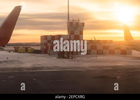 bâtiment de l'aéroport à l'aube sur la piste avec feu à éclats peint en carreaux rouges et blancs. vue sur la fenêtre de l'avion Banque D'Images