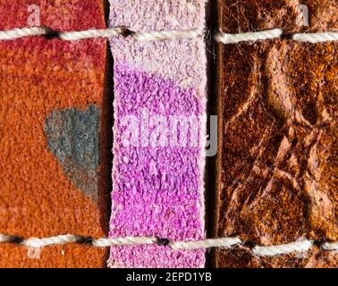 Photo macro de trois lacets en cuir recyclé et coloré avec fil de coton. Peut être utilisé comme toile de fond ou fond d'écran. Banque D'Images