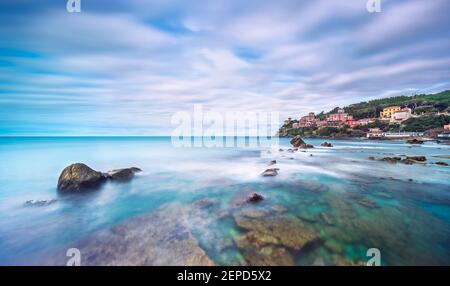 Rochers, mer douce et nuages dans le ciel, beau paysage en photographie en exposition longue. Baie de Quercetano, Castiglioncello, Toscane, Italie. Banque D'Images