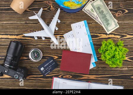 Documents, billets d'avion et autres fournitures de voyage sur fond de bois. Vue de dessus. Banque D'Images