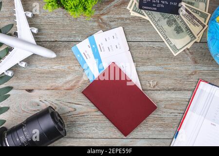 Documents, billets d'avion et autres fournitures de voyage sur fond de bois. Vue de dessus. Banque D'Images