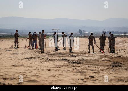 Pneu, Liban. 27 février 2021. Des volontaires libanais participent à une campagne de nettoyage des plages de la ville de Tyr, après un déversement de pétrole qui a déposé du goudron sur de grandes étendues de la côte dans la partie sud du Liban. Le goudron d'une marée noire qui polluait les plages d'Israël a également taché la côte sablonneuse de la ville portuaire de Tyr au Liban. Credit: Marwan Naamani/dpa/Alamy Live News Banque D'Images