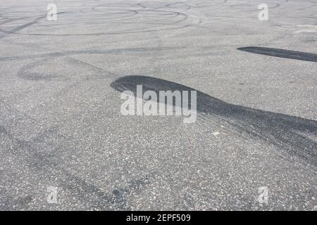 Piste de voiture avec traces de dérive en caoutchouc. Texture de fond de la chaussée asphaltée Banque D'Images