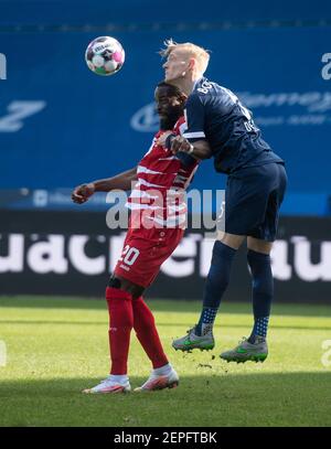 Bochum, Allemagne. 27 février 2021. Football : 2. Bundesliga, VfL Bochum - Würzburger Kickers, Matchday 23 à Vonovia Ruhrstadion. Le défenseur de Bochum Saulo DeCarli (r) et le buteur de Würzburg Ridge Munsy essayer d'obtenir le ballon. Crédit : Bernd Thissen/dpa - REMARQUE IMPORTANTE : Conformément aux règlements de la DFL Deutsche Fußball Liga et/ou de la DFB Deutscher Fußball-Bund, il est interdit d'utiliser ou d'avoir utilisé des photos prises dans le stade et/ou du match sous forme de séquences et/ou de séries de photos de type vidéo./dpa/Alay Live News Banque D'Images