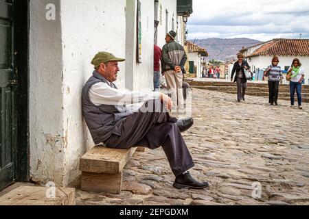 L'homme colombien a traversé le visage, assis à l'extérieur bar.Villa de Leyva place principale 500 ans vieille ville. Chaîne de montagnes. Boyaca, Colombie, Andes, Amérique du Sud Banque D'Images