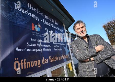 Koserow, Allemagne. 27 février 2021. Michael Raffelt, exploitant hôtelier de la Hanse-Kogge, se dresse à Koserow devant une affiche avec les mots « ouverture des hôtels avant Pâques ». Sur l'île d'Usedom, un producteur de vacances, les hôteliers ont lancé une campagne d'affiches le même jour, soulignant les conséquences imminentes de mois de fermetures forcées. Credit: Stefan Sauer/dpa/Alay Live News Banque D'Images