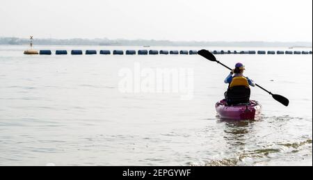 Vue arrière d'une femme en kayak. Pagayer le canoë ou le petit bateau. Kayak, canoë, pagayage Banque D'Images