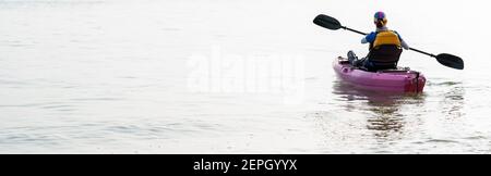 Vue arrière d'une femme en kayak. Pagayer le canoë ou le petit bateau. Kayak, canoë, pagayage Banque D'Images