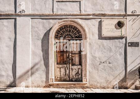 Ston, Croatie - 20 août 2020 : ancienne porte en bois sur façade en pierre avec plaque de constructeur dans la vieille ville Banque D'Images