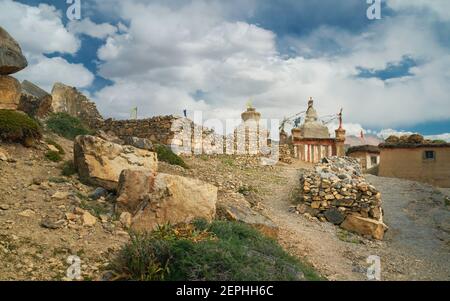 Chemin vers le mur traditionnel de pierre sèche menant à gompa bouddhiste et chorten sous ciel bleu nuageux dans le village himalayan de Tashigong, Himachal Pradesh, I Banque D'Images