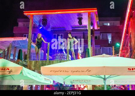 08-05-2018 Sunny Beach , Bulgarie . Une chanteuse en plein air accompagnée de deux danseuses du bikini. Sur le toit de la discothèque Banque D'Images