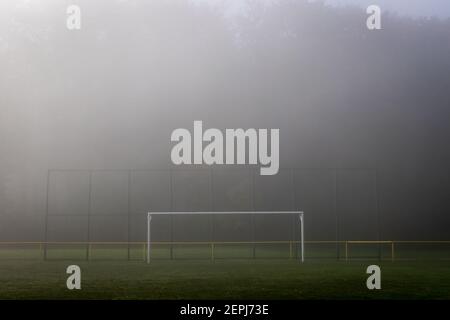 Vide le poteau de but de football dans le brouillard. Terrain de football dans la brume. Terrain de football en plein air Banque D'Images