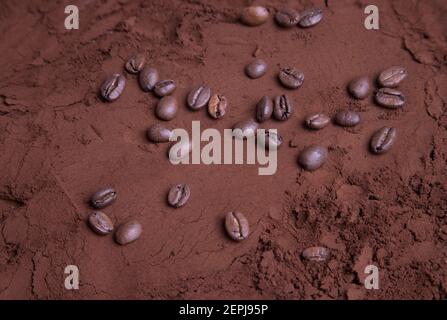 Grains de café éparpillés sur du café moulu torréfié. Banque D'Images