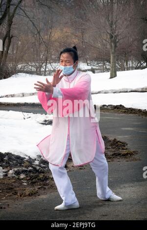 Une femme américaine chinoise d'âge moyen effectue avec élégance des exercices de danse de Tai Chi dans le parc de Kissena à Flushing, Queens, New York City. Banque D'Images