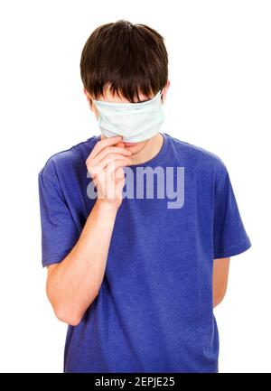 Le jeune homme cache son visage avec un masque de grippe isolé Sur le fond blanc Banque D'Images