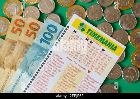 Minas Gerais, Brésil - 22 février 2021 : billets en espèces, pièces et billets de loterie Caixa Timemania Banque D'Images