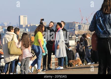 Londres, Royaume-Uni, 27 février 2021. Les gens se sont enfermés à Primrose Hill, dans le nord de Londres, pour profiter du soleil hivernal exceptionnellement chaud, malgré les restrictions de Covid. Il y avait une vue incroyable sur la ville par temps clair. Monica Wells/Alay Live News Banque D'Images