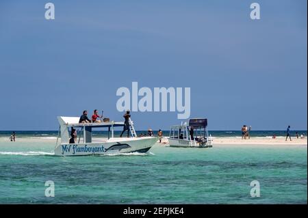 Un bateau à fond de verre amarré par une banque de sable à marée basse avec des gens sur le sable, Diani, Kenya Banque D'Images