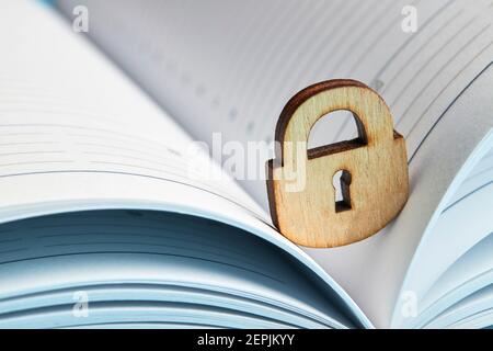 concept de confidentialité des affaires. cadenas en bois sur un bloc-notes ouvert. espace de copie Banque D'Images