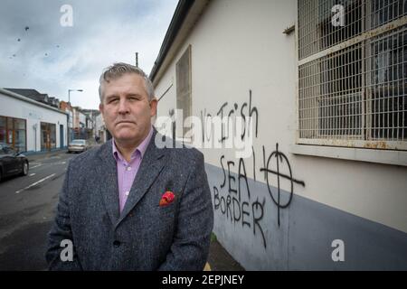 LARNE, IRLANDE DU NORD - février 24 : Keith Turner UUP devant des graffitis loyalistes menaçants destinés au personnel portuaire de Larne, dans le Nord Banque D'Images