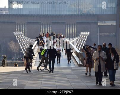 Personnes marchant le long du Millennium Bridge avec Tate Modern en arrière-plan, Londres, Royaume-Uni. Banque D'Images