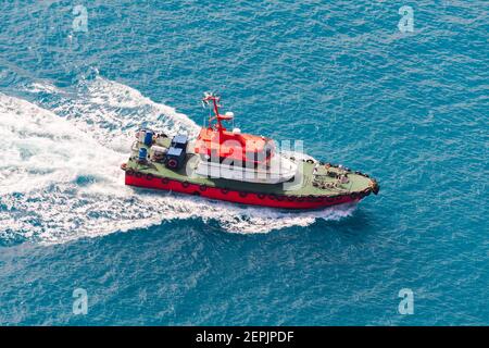 Bateau-pilote rouge avec pont vert sur le chemin. Mer Rouge, port de Djeddah, Arabie Saoudite Banque D'Images