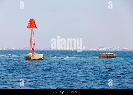 Tour de navigation rouge encadrée avec une marque triangulaire se dresse près de l'épave dans l'eau du golfe Persique, Arabie Saoudite Banque D'Images