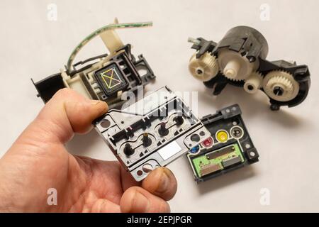 mécanisme de tête d'impression d'imprimante à jet d'encre couleur démonté avec pompe et électronique carte de commande dans la main de l'ingénieur Banque D'Images