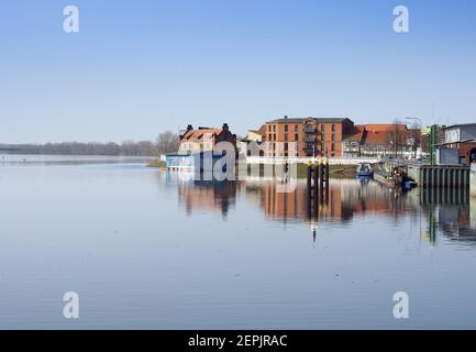 Wittenberge, Allemagne. 25 février 2021. Les bâtiments de la promenade d'Elbuferpromenade et du Stepenitz au Nedwighafen se reflètent dans l'eau. Credit: Soeren Stache/dpa-Zentralbild/ZB/dpa/Alay Live News Banque D'Images