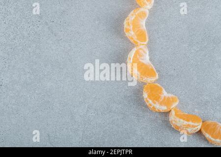Tranches de mandarine délicieuse sur fond gris Banque D'Images