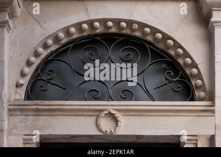 Une fenêtre supérieure semi-circulaire, avec une grille en fer stylisée d'une porte d'une maison arabe qui a été abandonnée en 1948 dans le quartier de Musrara également connu sous son nom hébreu, Morasha dans Jérusalem-Ouest Israël Banque D'Images