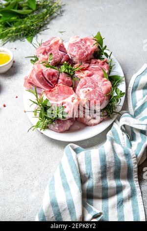 Porc Osso Buco, shin queues de porc aux herbes aromatiques fraîches sur plateau blanc marmol Banque D'Images