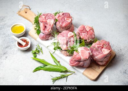 Porc Osso Buco, shin queues de porc aux herbes aromatiques fraîches sur plateau blanc marmol Banque D'Images