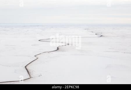 Vue aérienne en hiver de la route d'Inuvik-Tuktoyaktuk (construite au-dessus du pergélisol), en gravier toutes saisons de 139 km, dans l'Arctique canadien. Image Banque D'Images