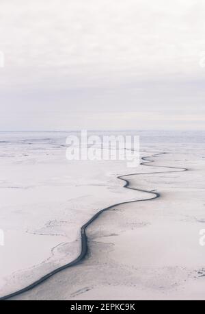 Vue aérienne en hiver de la route d'Inuvik-Tuktoyaktuk (construite au-dessus du pergélisol), en gravier toutes saisons de 139 km, dans l'Arctique canadien. Image Banque D'Images