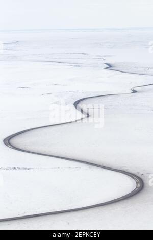 Vue aérienne en hiver de la route d'Inuvik-Tuktoyaktuk (construite au-dessus du pergélisol), en gravier toutes saisons de 139 km, dans l'Arctique canadien. Image Banque D'Images