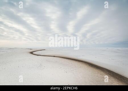 Vue aérienne en hiver de la route d'Inuvik-Tuktoyaktuk (construite au-dessus du pergélisol), en gravier toutes saisons de 139 km, dans l'Arctique canadien. Image Banque D'Images