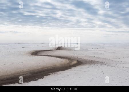 Vue aérienne en hiver de la route d'Inuvik-Tuktoyaktuk (construite au-dessus du pergélisol), en gravier toutes saisons de 139 km, dans l'Arctique canadien. Image Banque D'Images