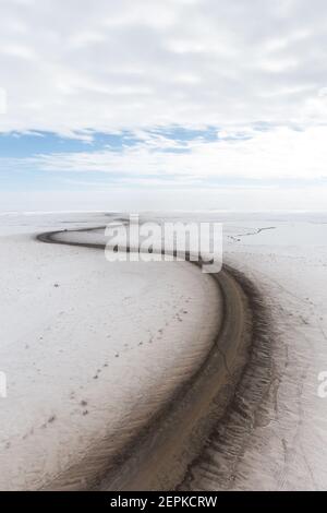 Vue aérienne en hiver de la route d'Inuvik-Tuktoyaktuk (construite au-dessus du pergélisol), en gravier toutes saisons de 139 km, dans l'Arctique canadien. Image Banque D'Images