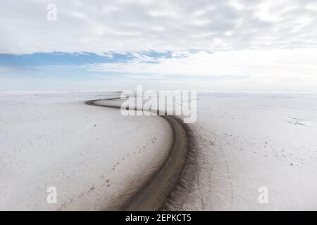 Vue aérienne en hiver de la route d'Inuvik-Tuktoyaktuk (construite au-dessus du pergélisol), en gravier toutes saisons de 139 km, dans l'Arctique canadien. Image Banque D'Images